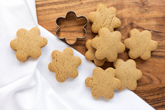 gingerbread cookies and cutter on a white kinchen towel