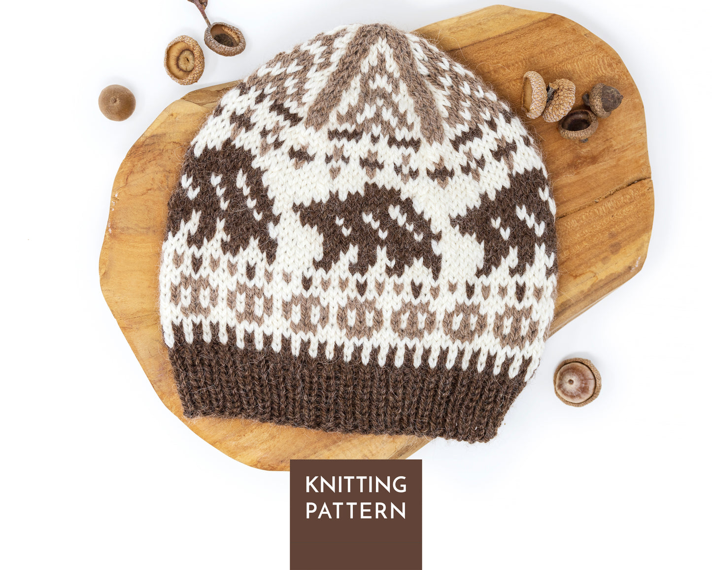 Bear Selbu hat, featuring a bear motif in brown and white, displayed on a wooden board woth acorns