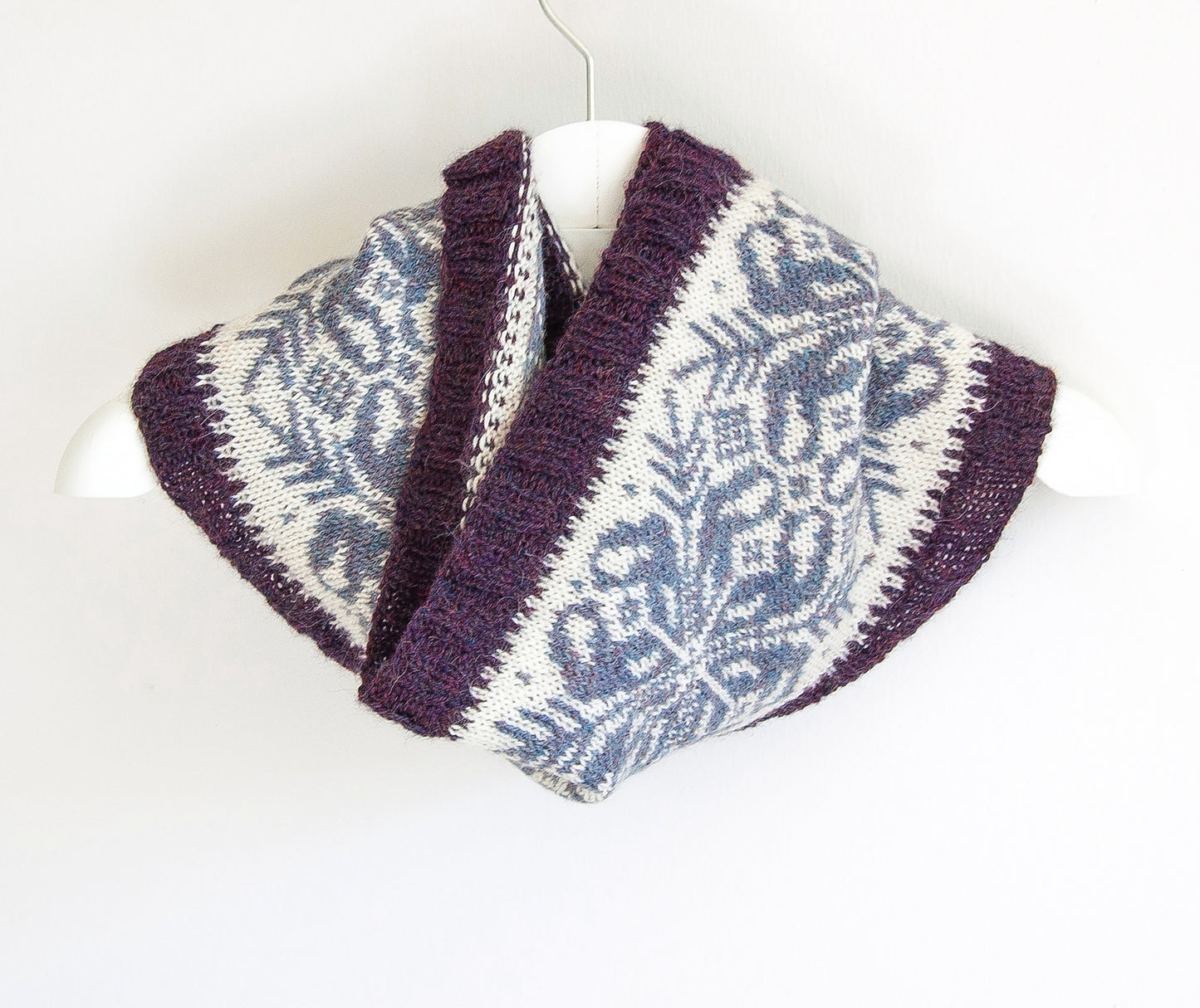 hand-knitted Fair Isle cowl in Snowflake pattern made from purple and white alpaca wool yarn