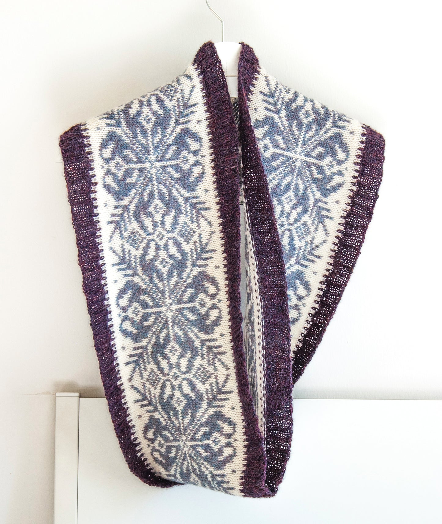 hand-knitted Fair Isle cowl in Snowflake pattern made from purple and white alpaca wool yarn