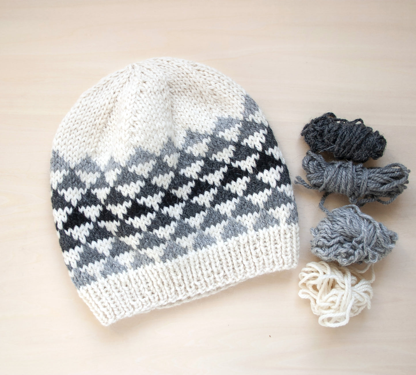 white, grey and black wool hand-knitted Fair Isle beanie hat in triangles knitting pattern