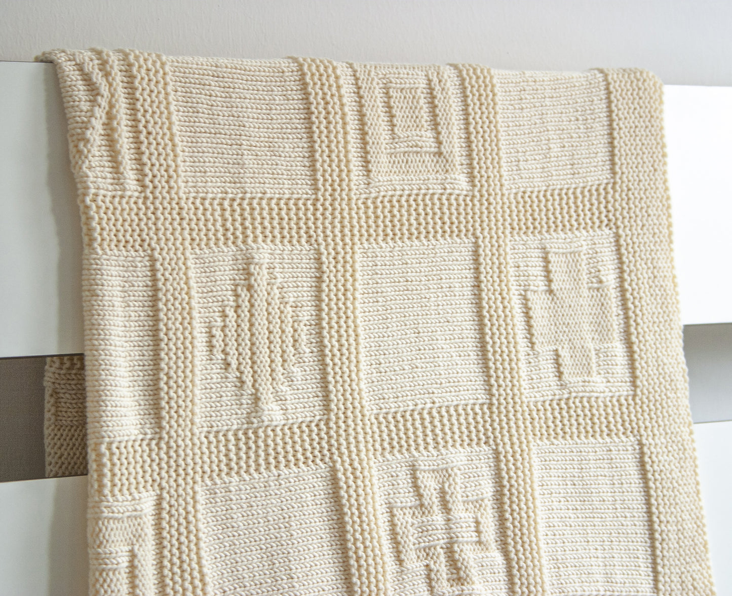White merino wool hand-knitted baby blanket in geometric pattern