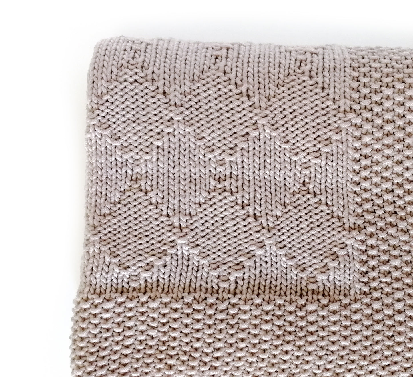 close up for beige hand-knitted baby blanket in Harlequin pattern
