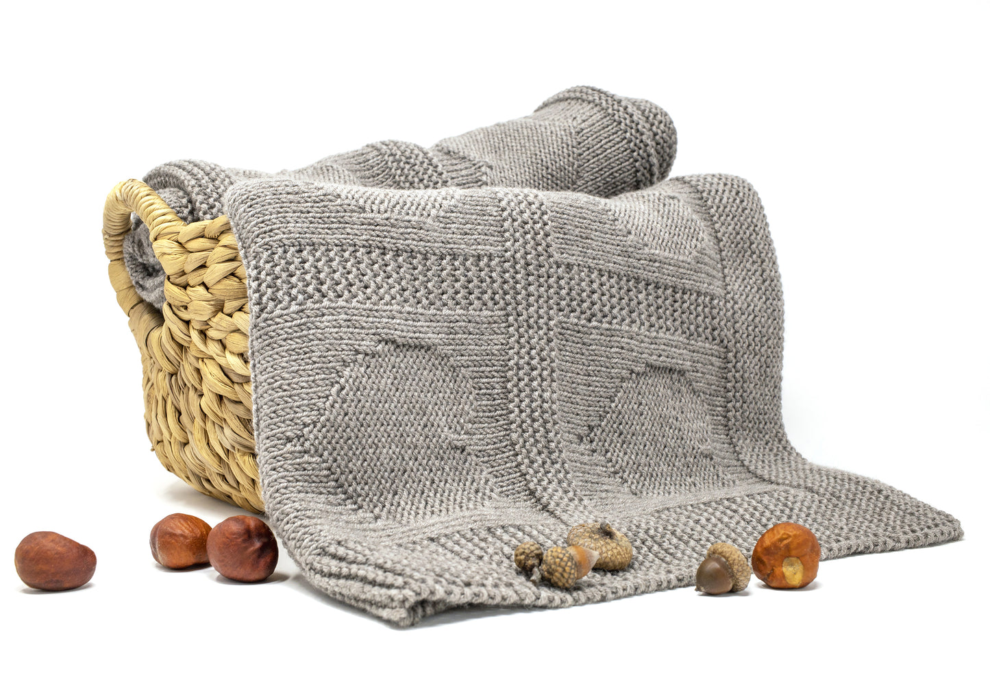 beige superwash merino wool yarn hand-knitted baby blanket in Hearts knitting pattern in a basket