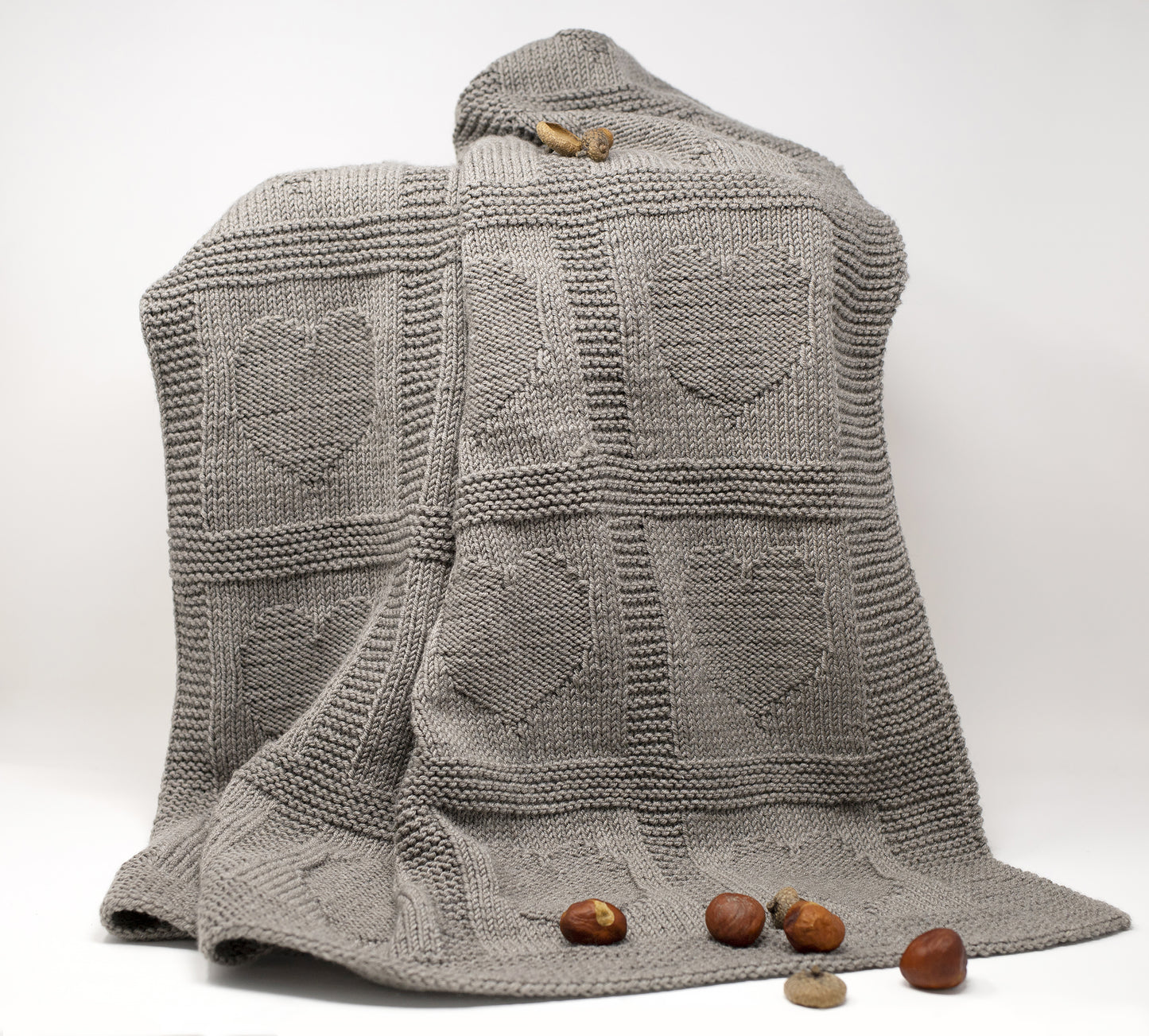 A beige brown merino wool hand-knitted baby blanket in Hearts textured pattern