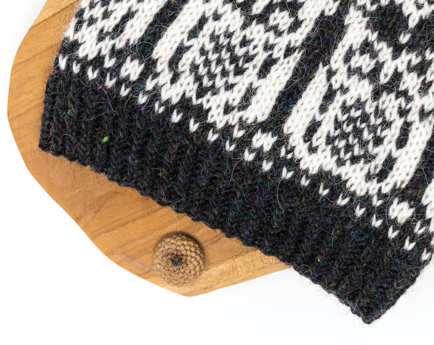 Black and white knitted hat on a wooden surface close up