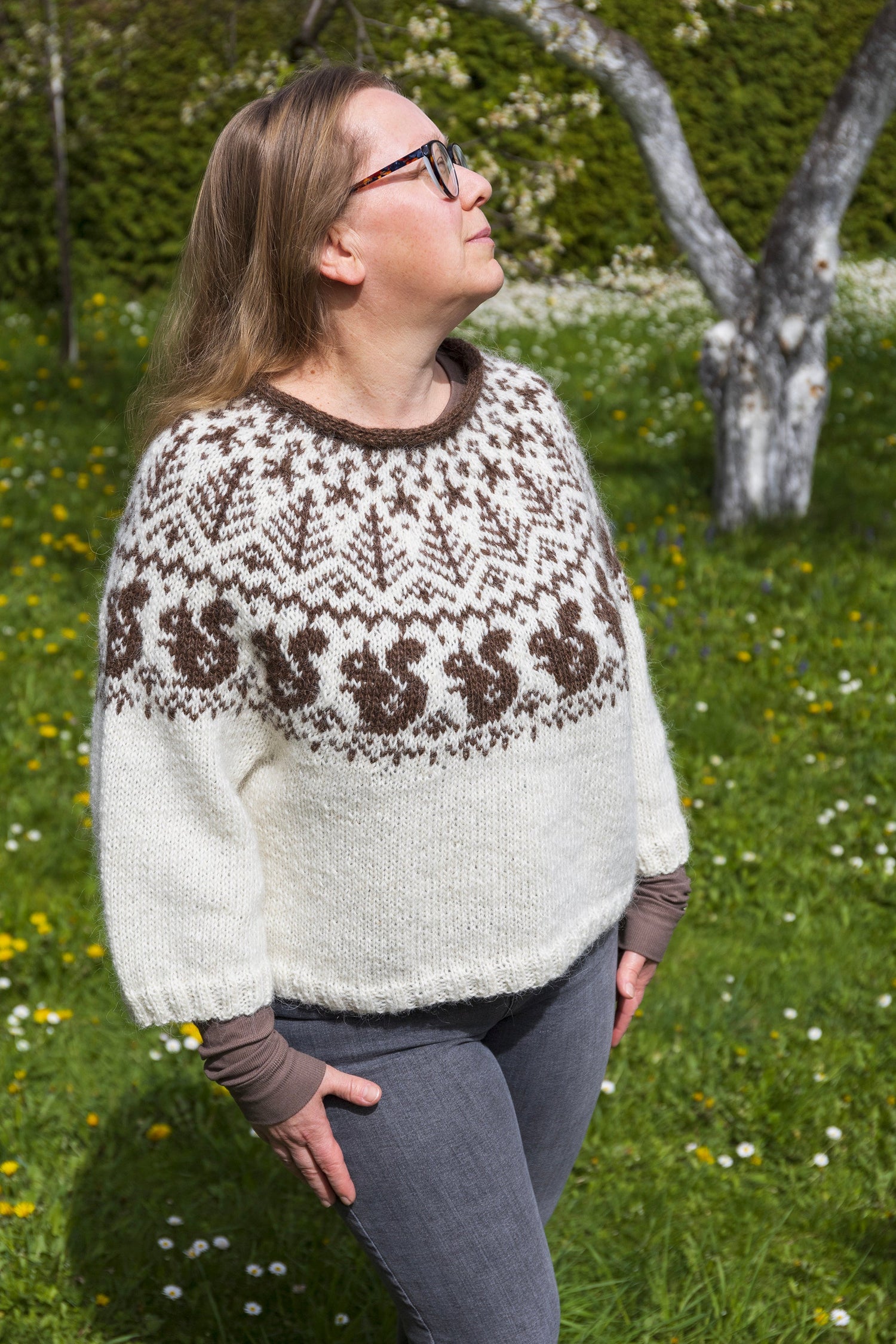 woman performs white and brown lopapeysa sweater with squirrel motif
