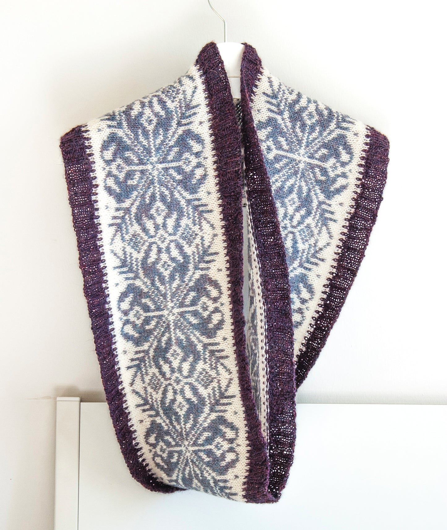 hand-knitted Fair Isle cowl  in Snowflake pattern made from purple and white alpaca wool yarn