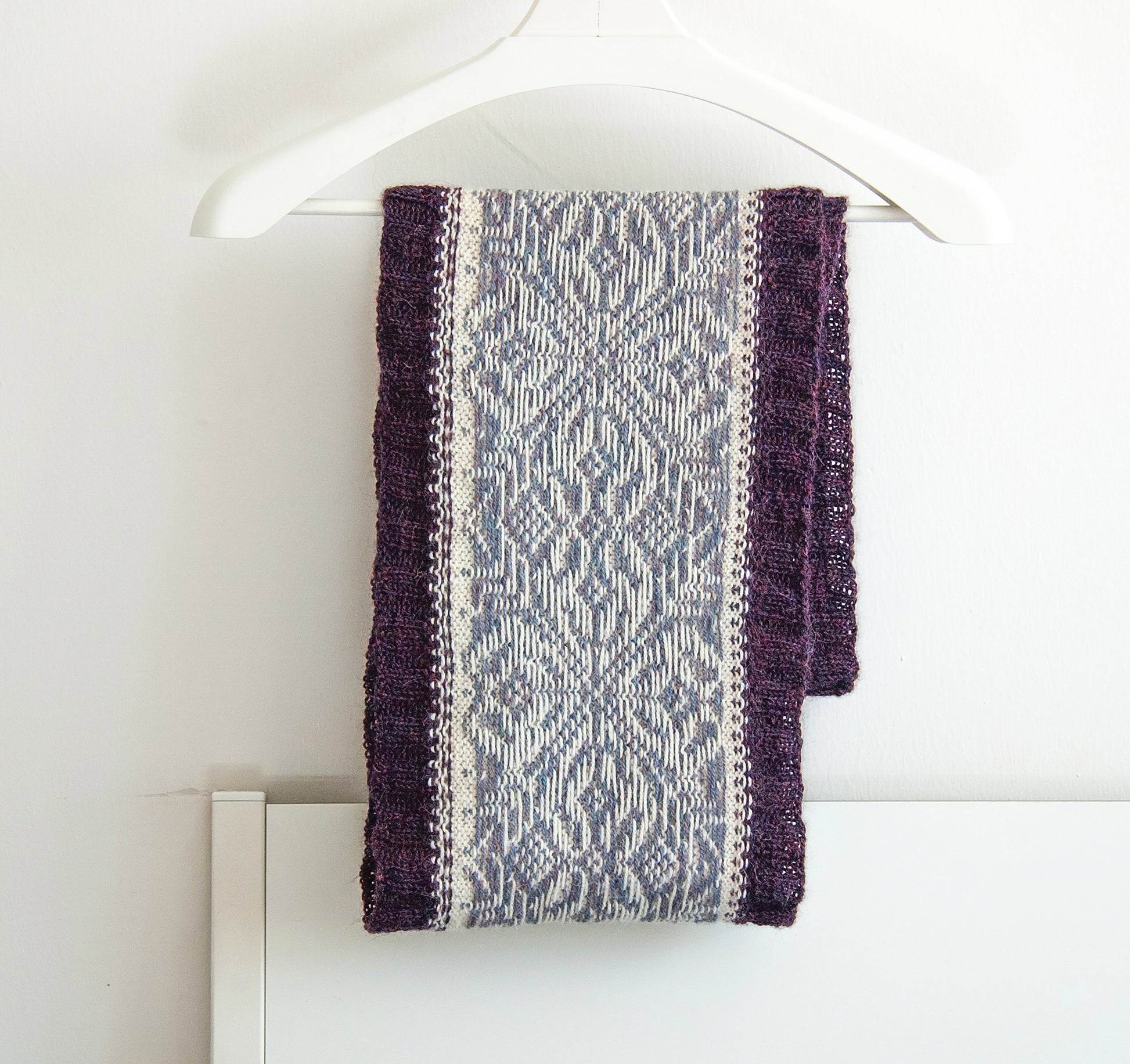 hand-knitted Fair Isle cowl  in Snowflake pattern made from purple and white alpaca wool yarn, wrong side