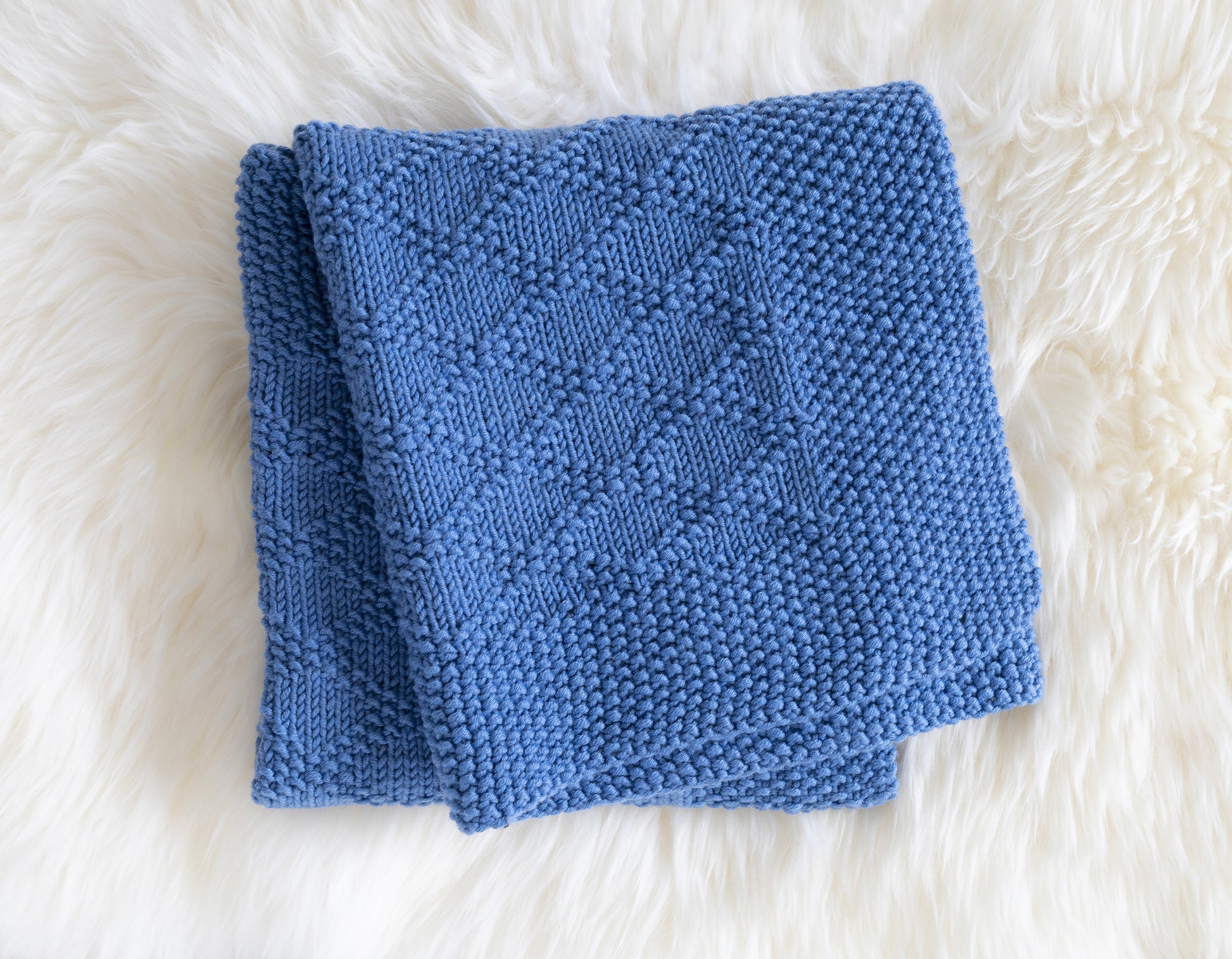 Blue merino wool hand-knitted blanket in Charles Brocade pattern