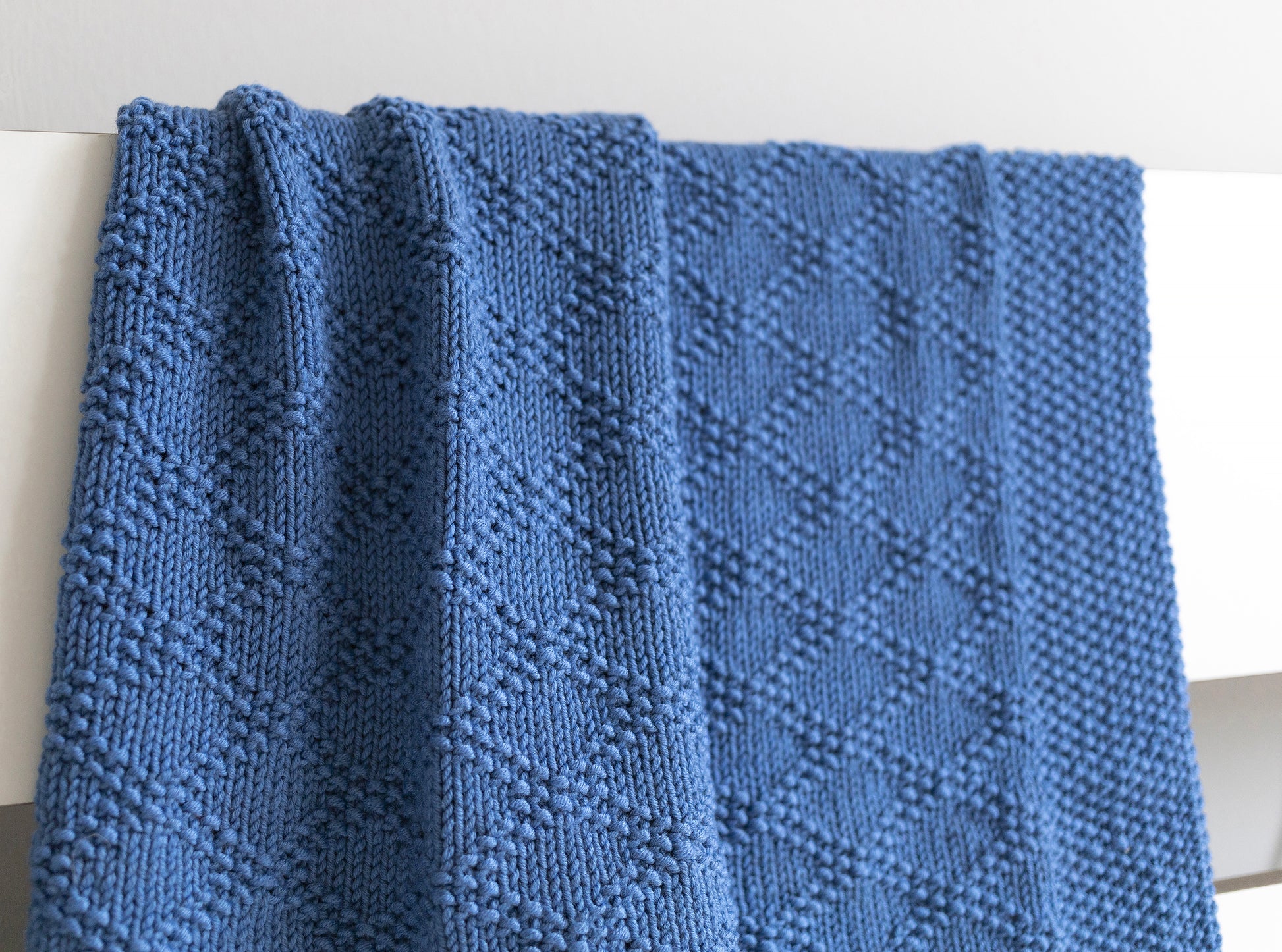 Close up for Merino wool hand-knitted baby blanket in Charles Brocade knitting pattern