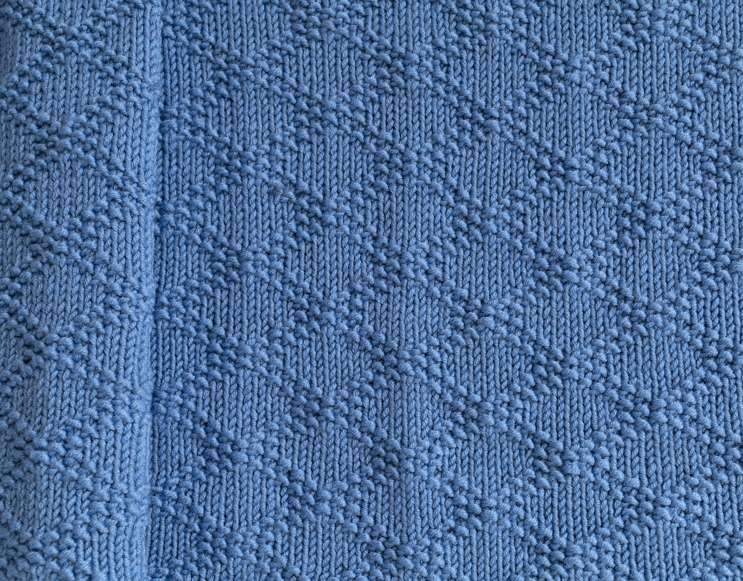Texture of Blue merino wool hand-knitted blanket in Charles Brocade pattern