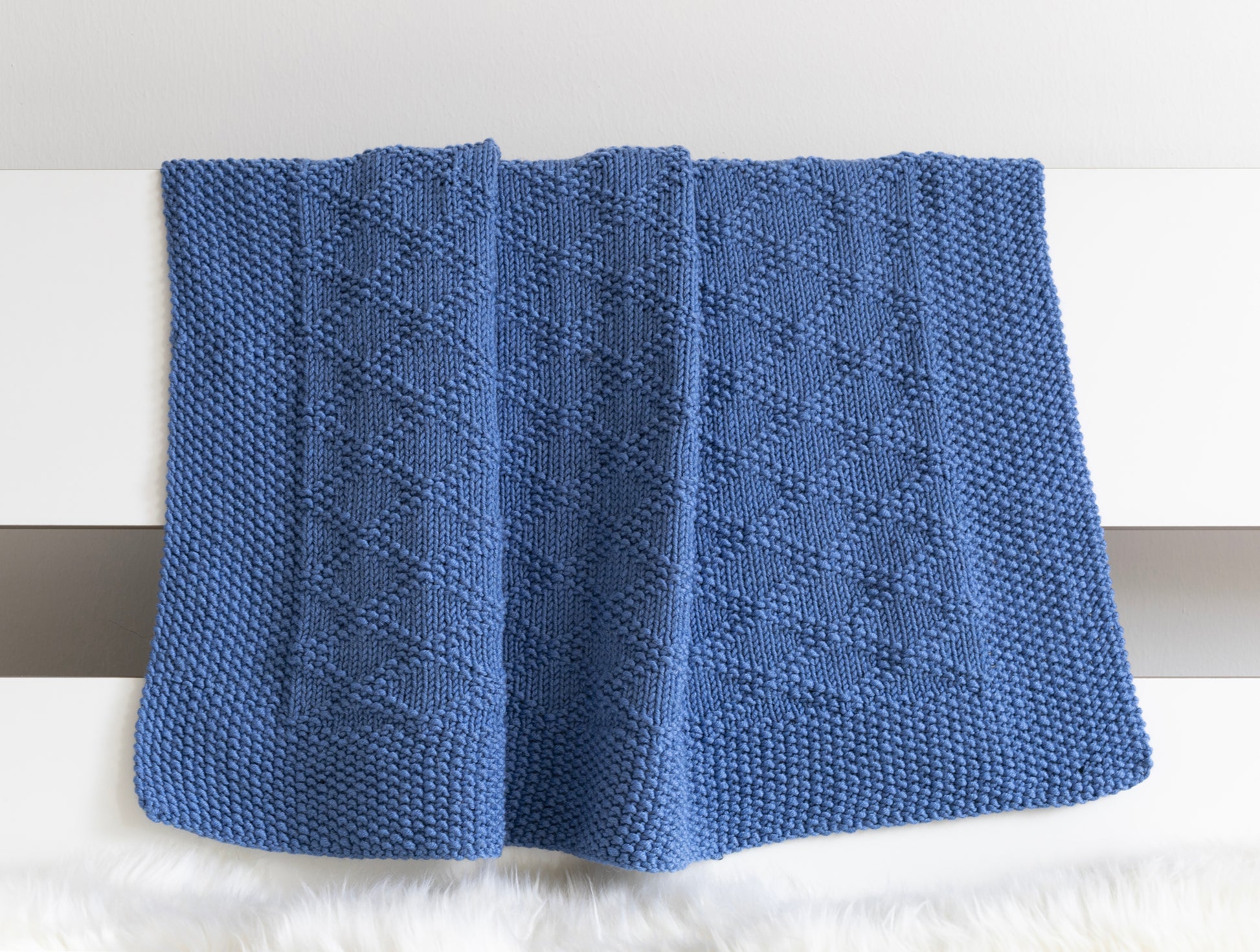Blue merino wool hand-knitted baby blanket in Charles Brocade knitting pattern