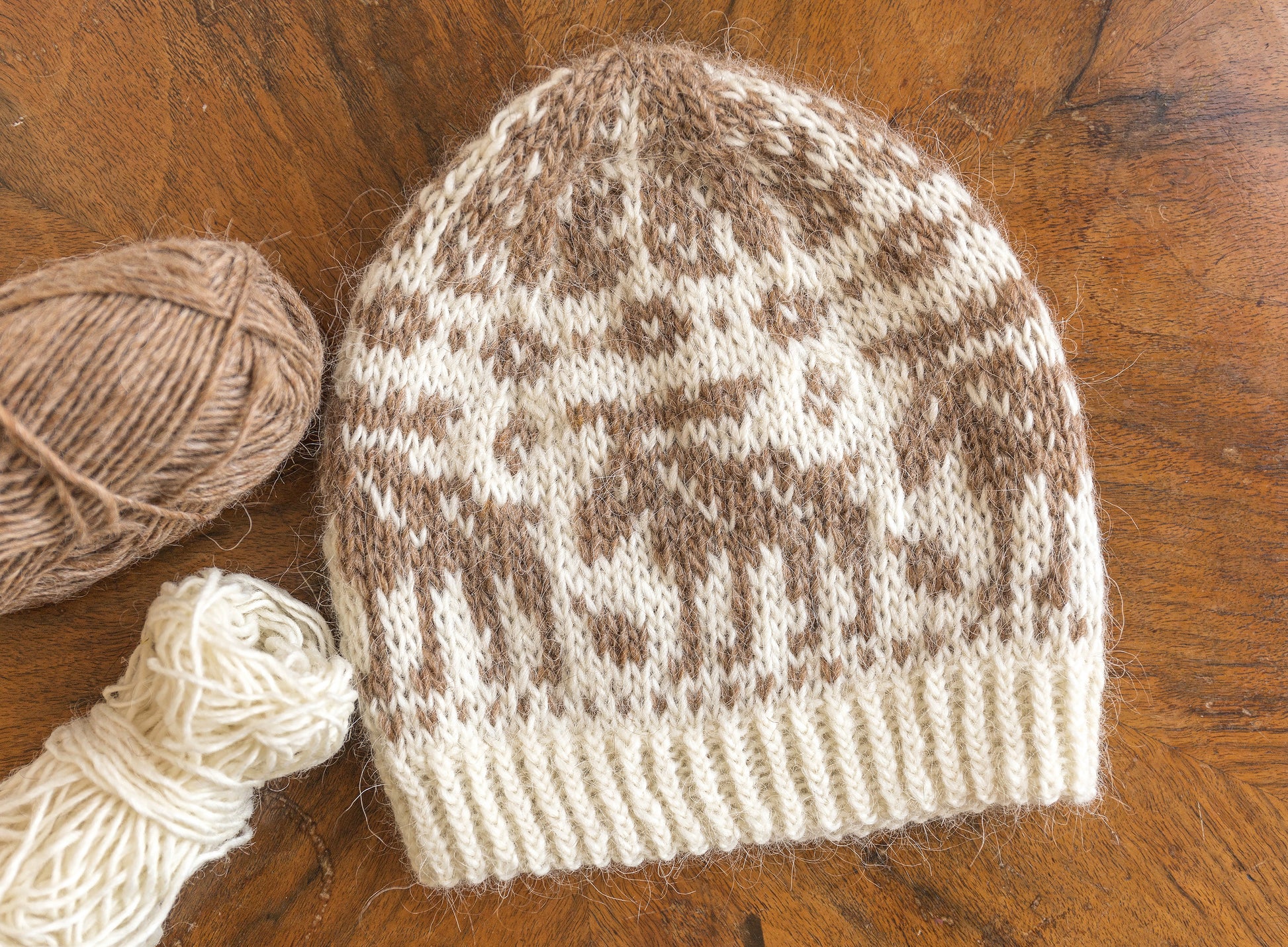 Knitted hat with yarn on a wooden surface