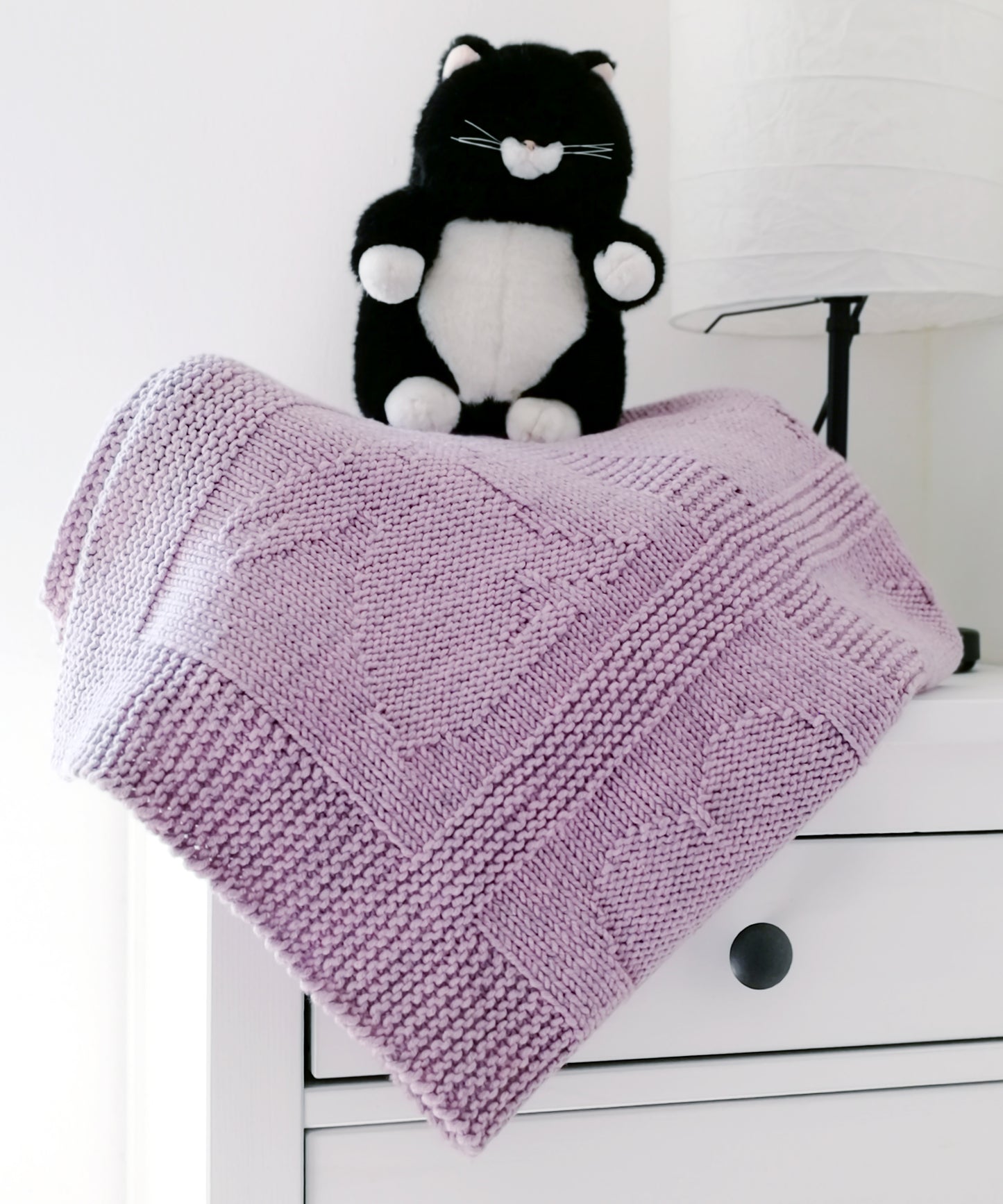 Purple superwash merino wool yarn hand-knitted baby blanket in Hearts & Bunnies knitting pattern