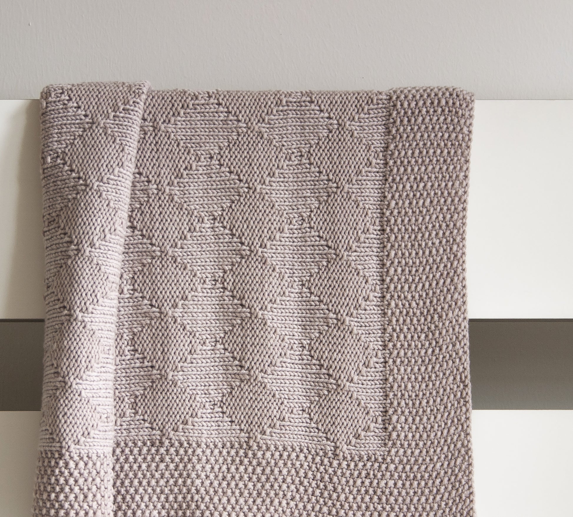Beige hand-knitted Harlequin baby blanket knitting pattern, beige textured diamond design