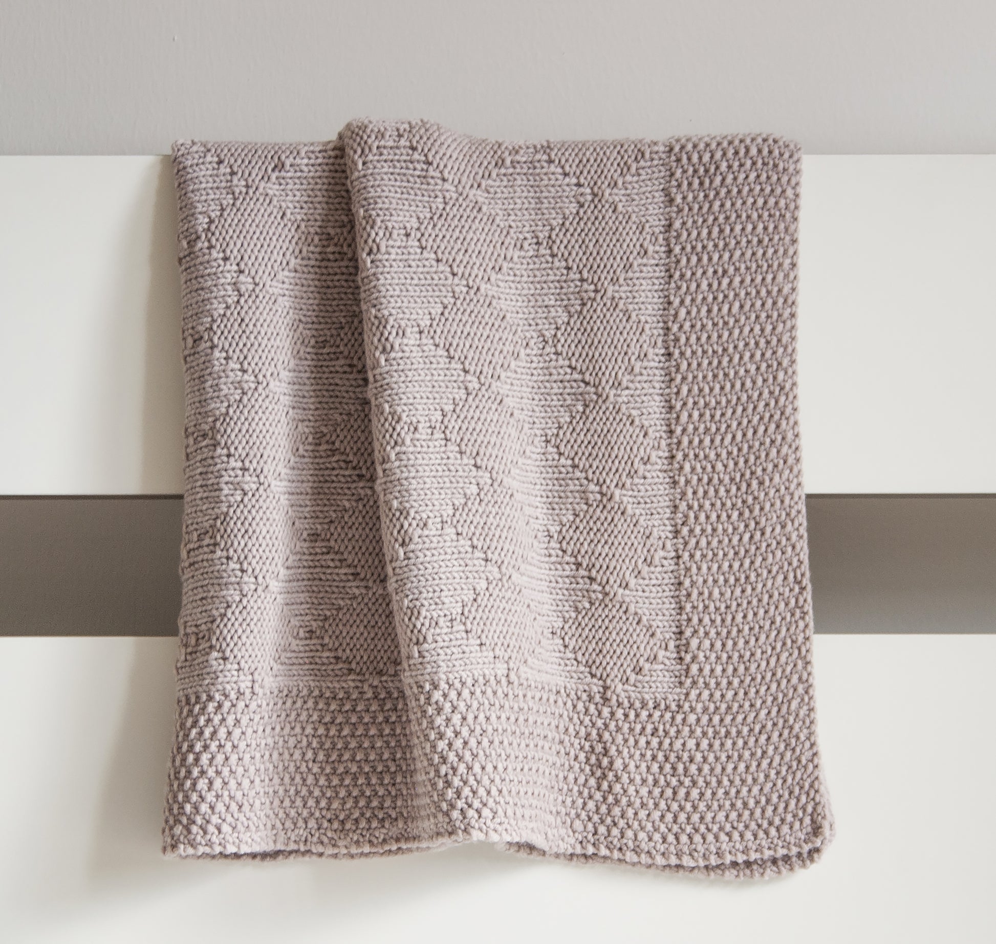 Beige hand-knitted baby blanket in Harlequin pattern