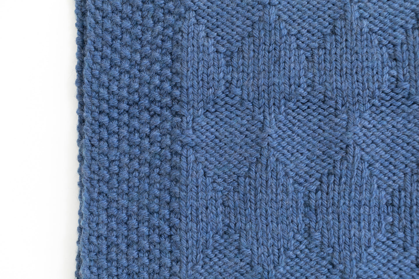 close up for Blue superwash wool hand-knitted baby blanket in Harlequin pattern
