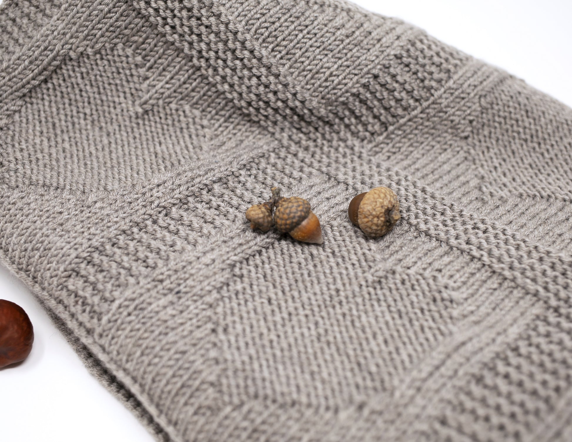 details of beige superwash merino wool yarn hand-knitted baby blanket in Hearts knitting pattern