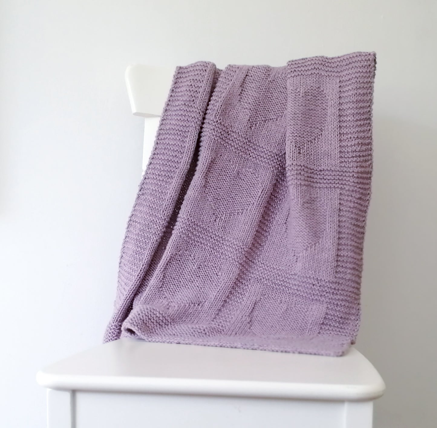purple merino wool hand-knitted baby blanket in Hearts knitting pattern
