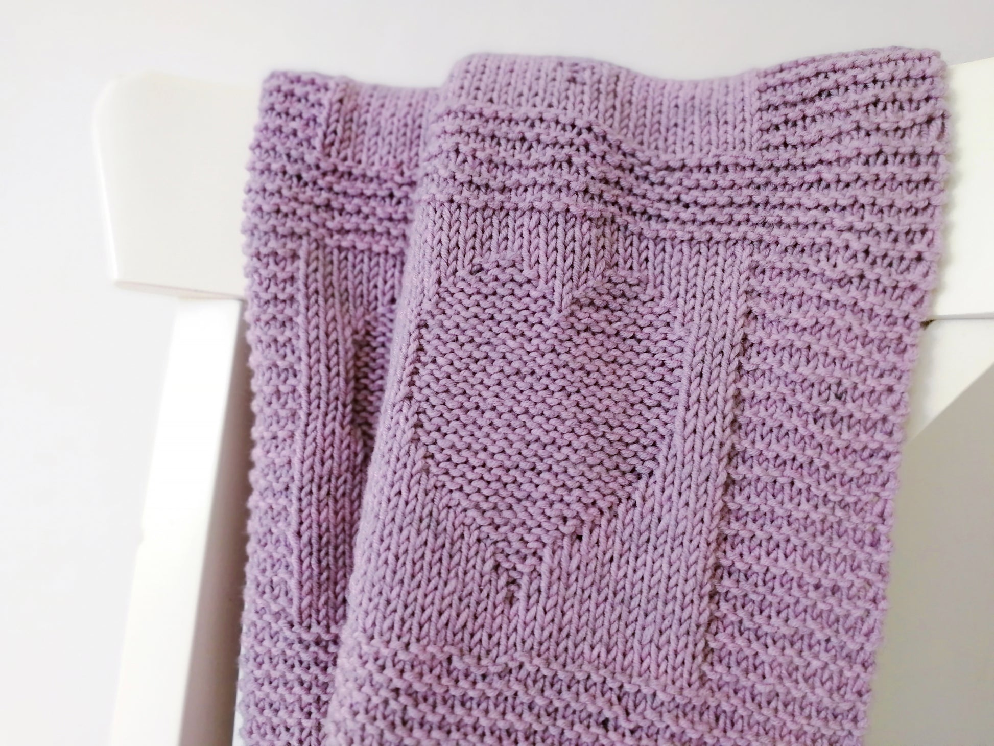 close up for Purple superwash merino wool yarn hand-knitted baby blanket in Hearts knitting pattern