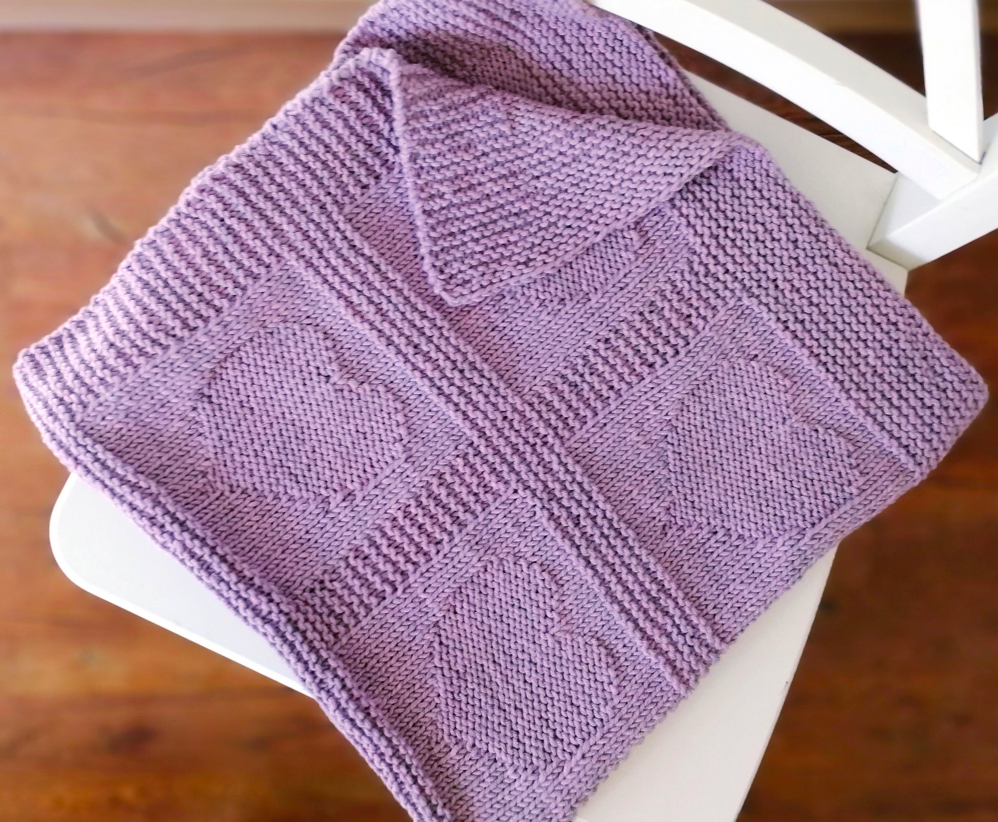 Purple superwash merino wool yarn hand-knitted baby blanket in Hearts knitting pattern