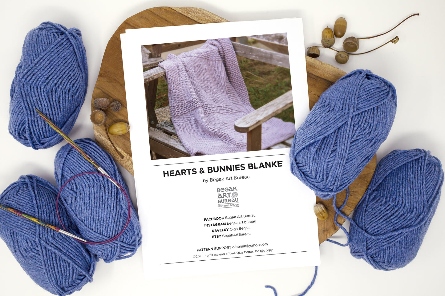 Hearts & Bunnies baby blanket knitting pattern with blue yarn balls