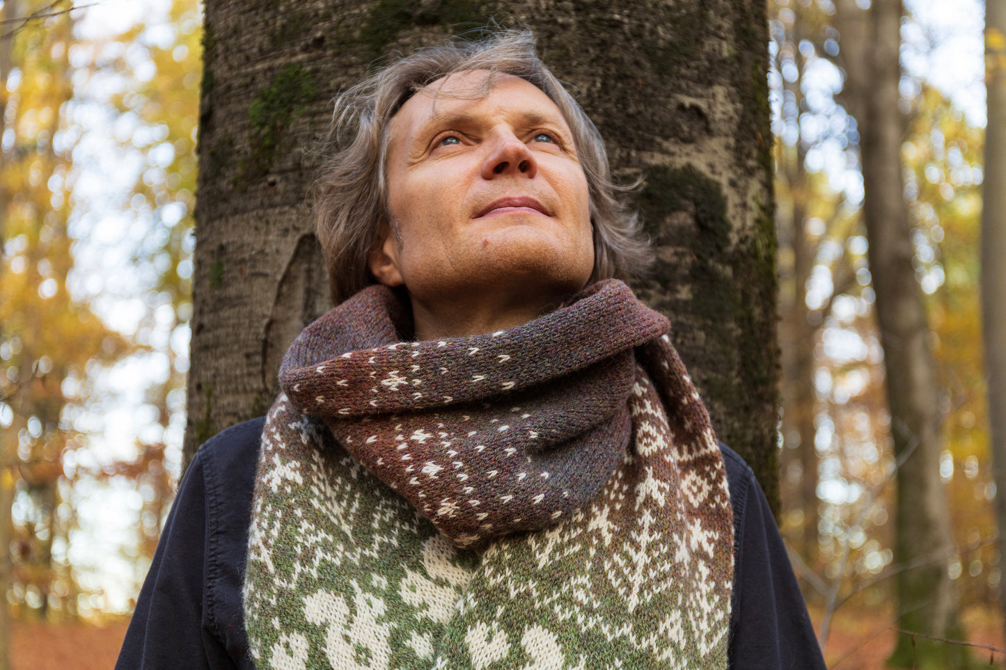 Person wearing Lahemaa Squirrel Fair Isle scarf in a forest setting