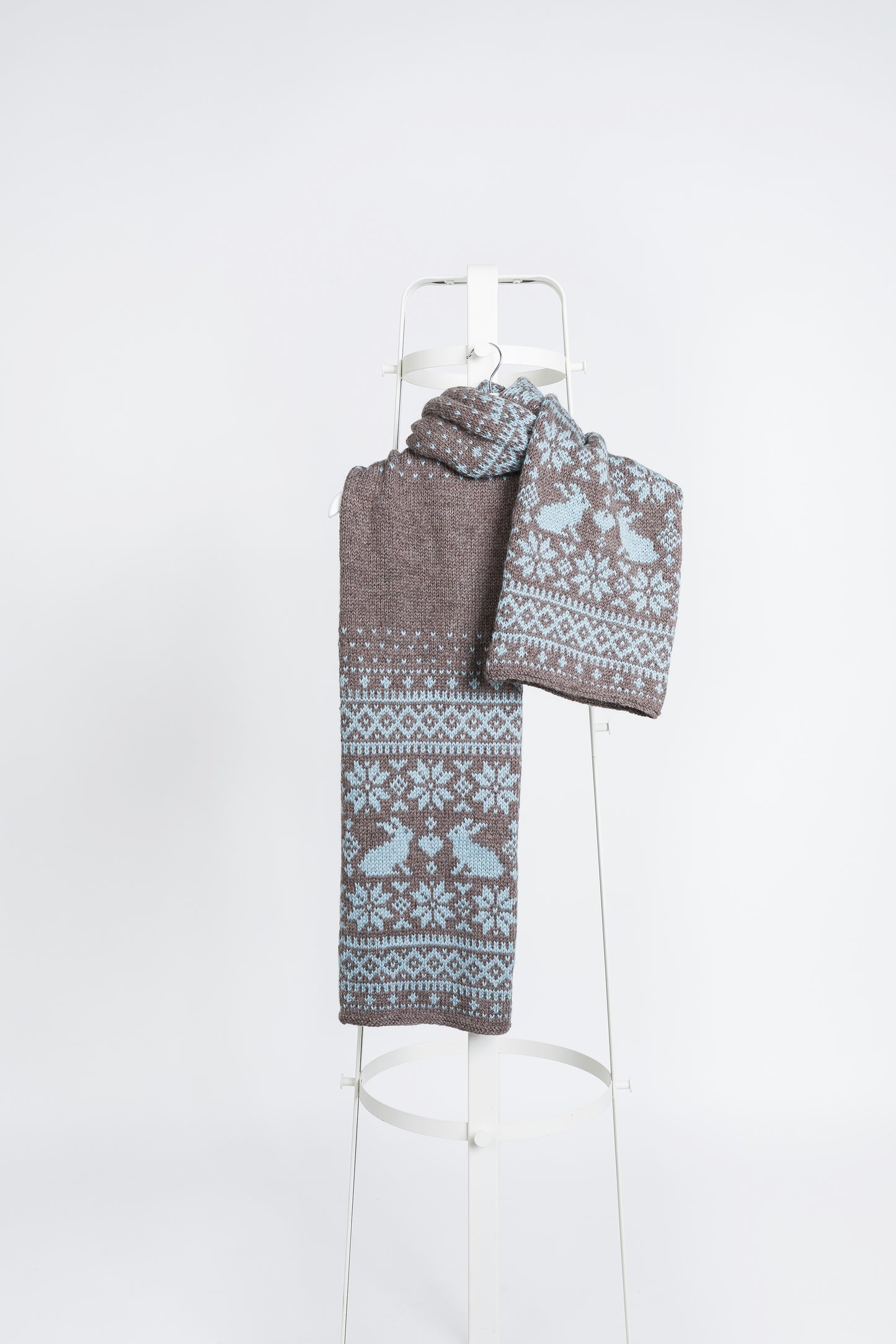 Brown and blue wool long hand-knitted Fair Isle scarf in Bunny Rabbits knitting pattern on a white background