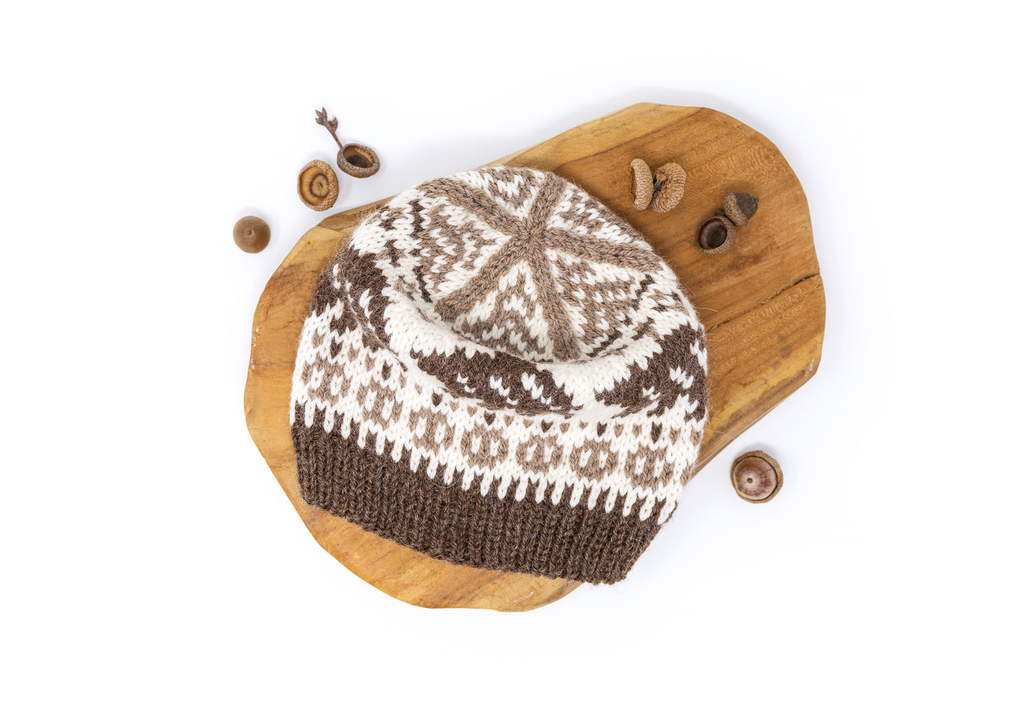 Knitted hat with a bear pattern on a wooden board.