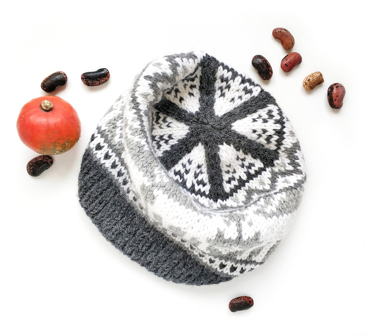 A crown of a gray and white wool hand-knitted Fair Isle beanie hat with moose motif