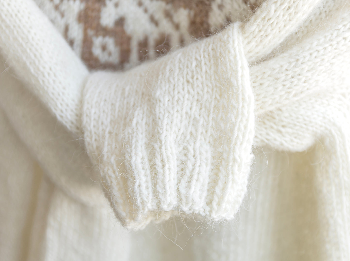Close-up of a white knitted sweaters ribbed cuffs