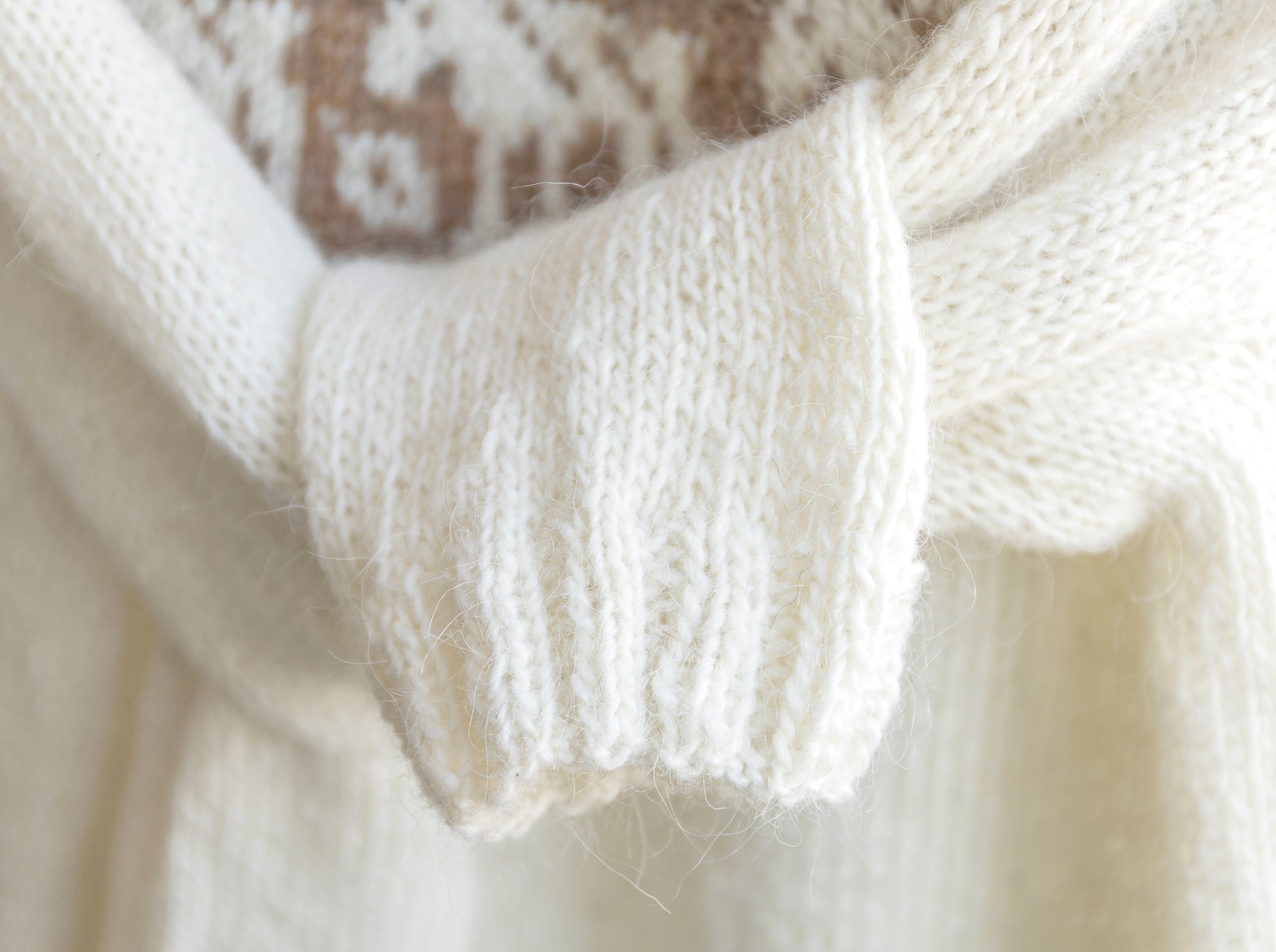 Close-up of a white knitted sweaters ribbed cuffs