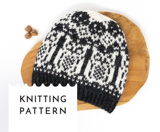 Owl Black and white knitted hat on a wooden board with 'Knitting Pattern' text.