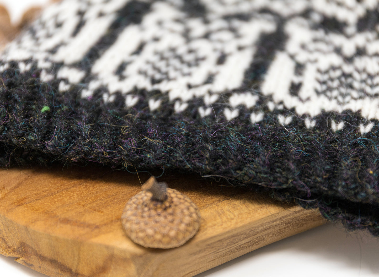 Knitted hat rib with a black and white pattern on a wooden surface