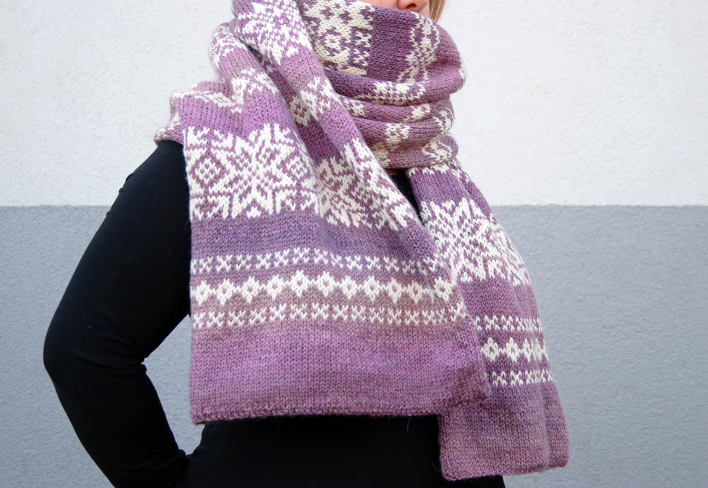 a woman wearing a purple and white Fair Isle hand-knitted scarf against a plain background