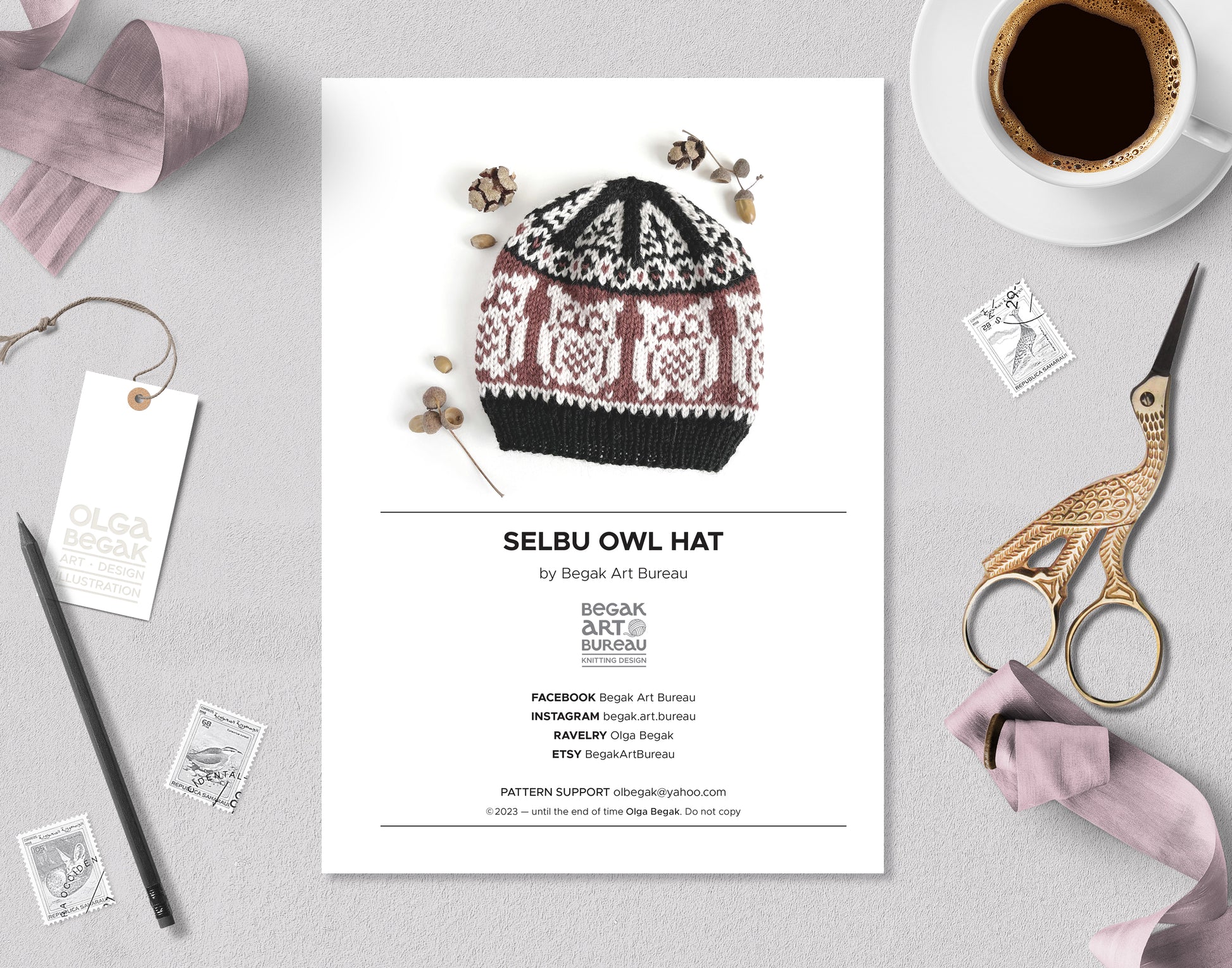 Owl Selbu hat knitting pattern booklet accompanied with stationery, ribbons and a cup of coffee