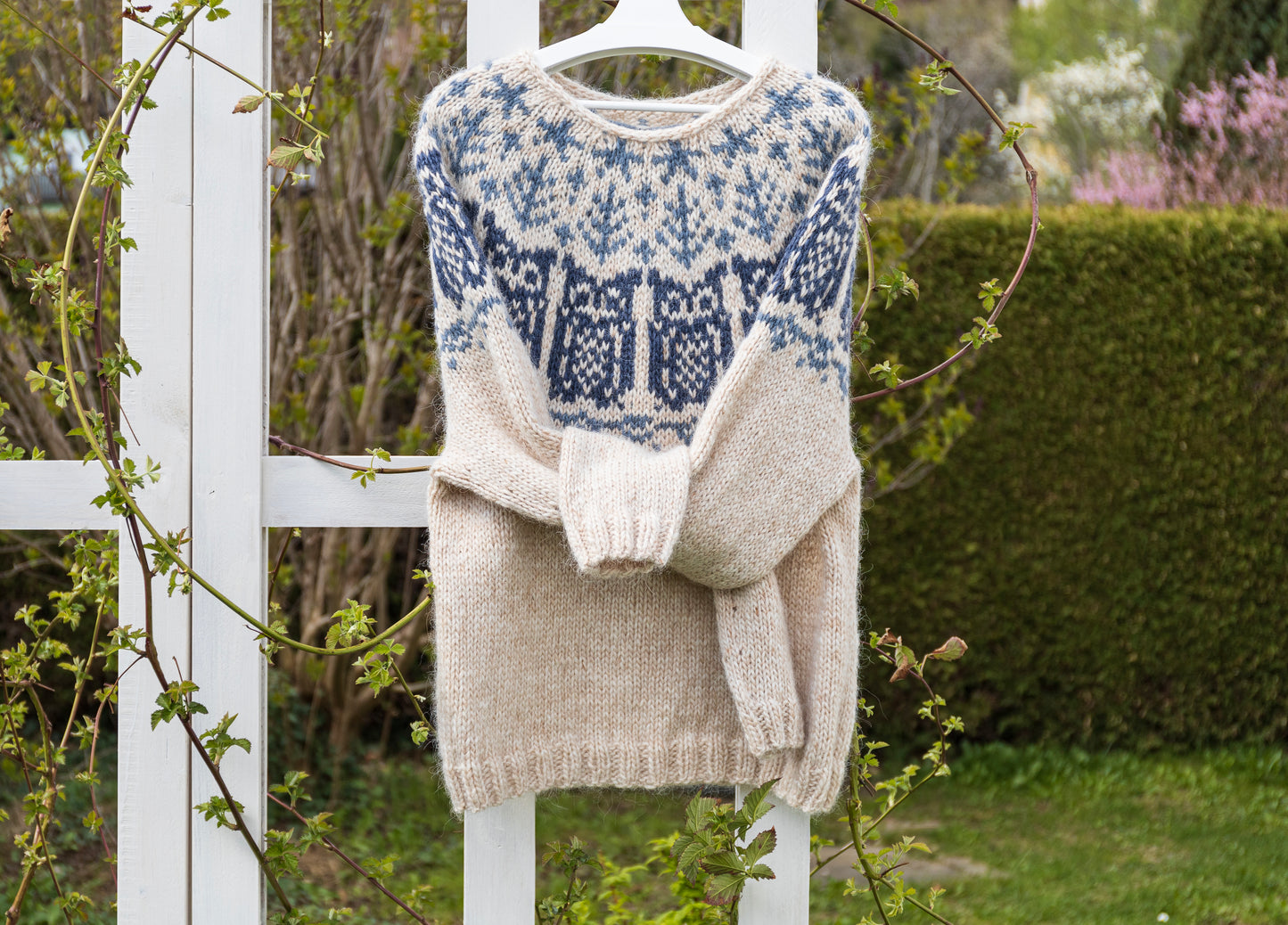 Owl Icelandic lopapeysa sweater displayed in the garden
