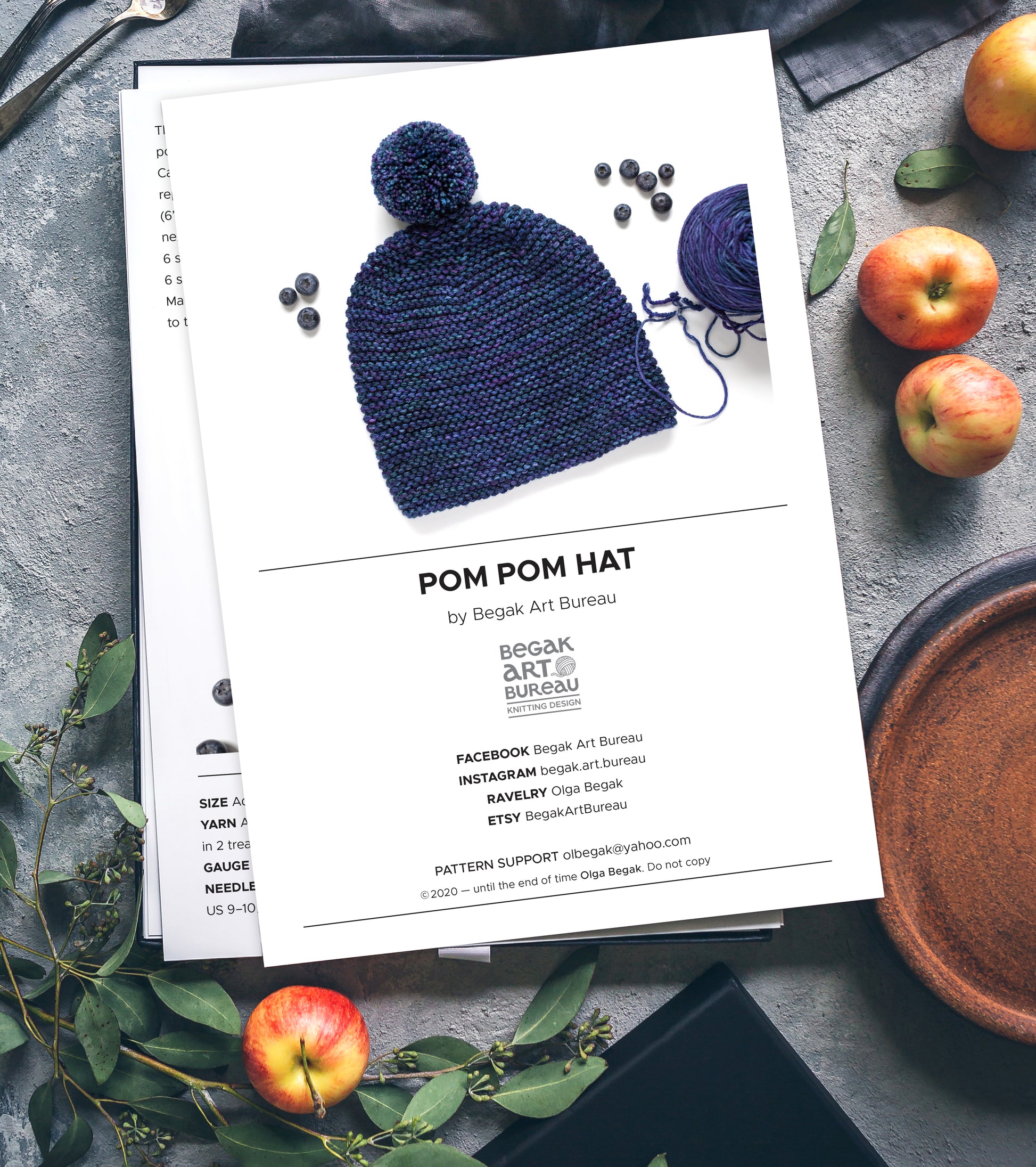 Pom pom garter stitch hat knitting pattern booklet on a table