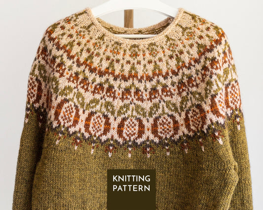 A knitted sweater shown hanging on a white hanger against a light gray background. The sweater has a beige  base with a detailed multicolor Fair Isle yoke in olive green, rust orange, and brown, and a solid olive green lower body.