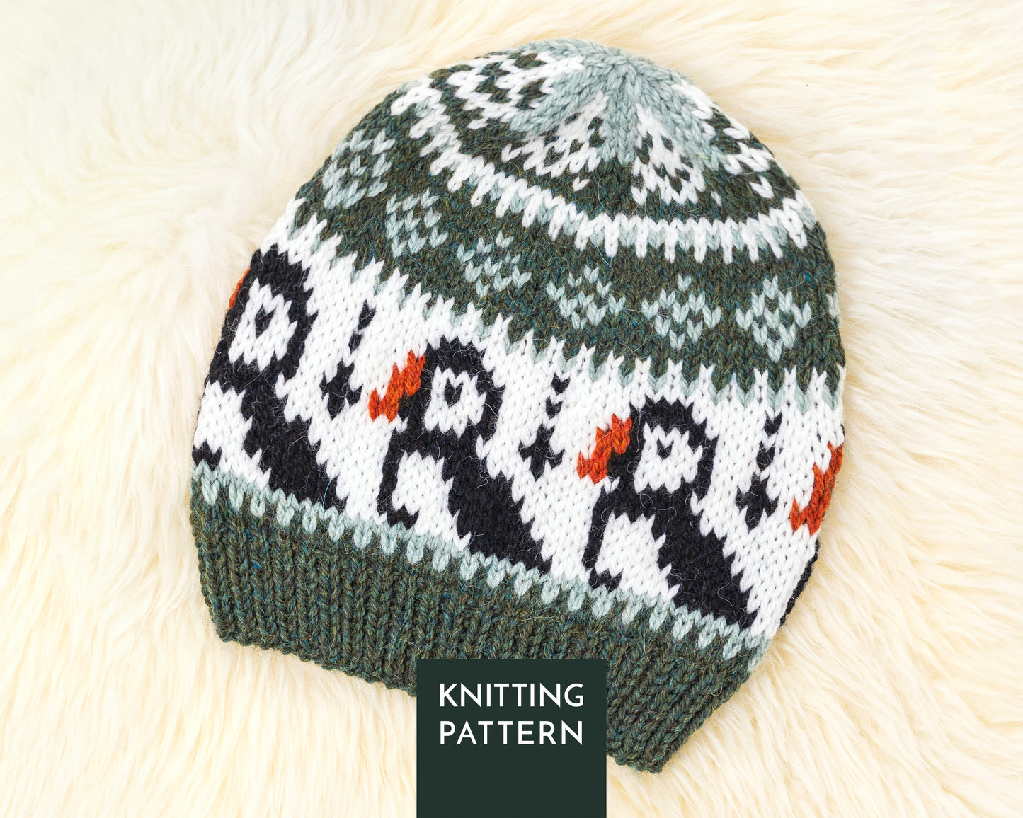 A knitted beanie hat with a Fair Isle style pattern featuring puffins, shown on a soft white fur background