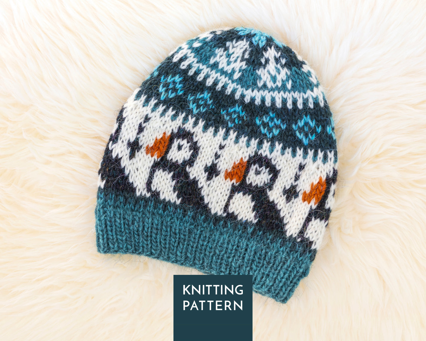 A knitted beanie hat with a puffin and snowflake pattern, displayed on a soft white faux fur background.