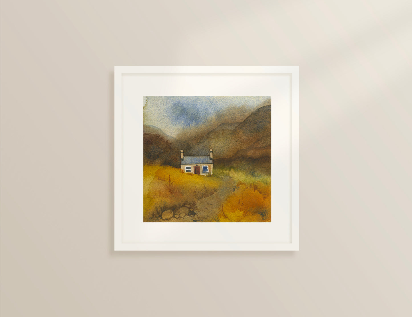 framed watercolor painting with small bothy in the field with a road leads to the house and mountains on the background