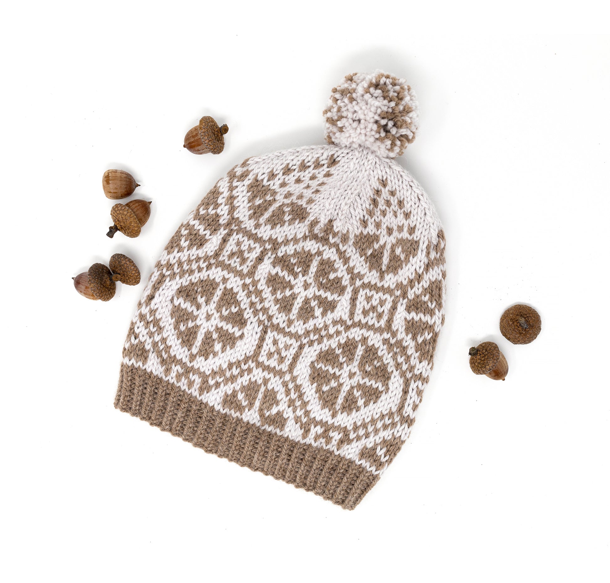 Knitted hat with a wheels motif and pom-pom on a white background