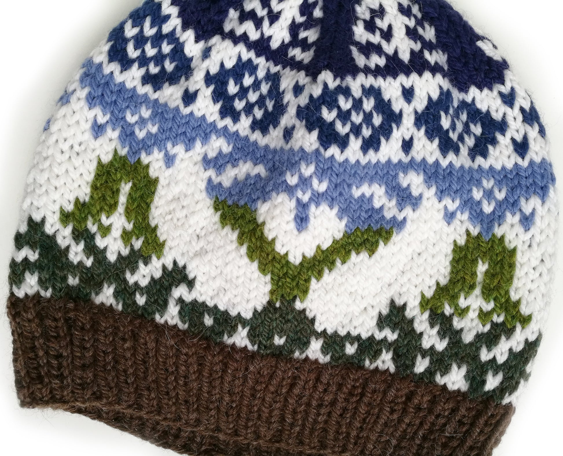 close up for green, brown, blue and white wool hand-knitted Fair Isle beanie hat in Bunny Rabbit knitting pattern
