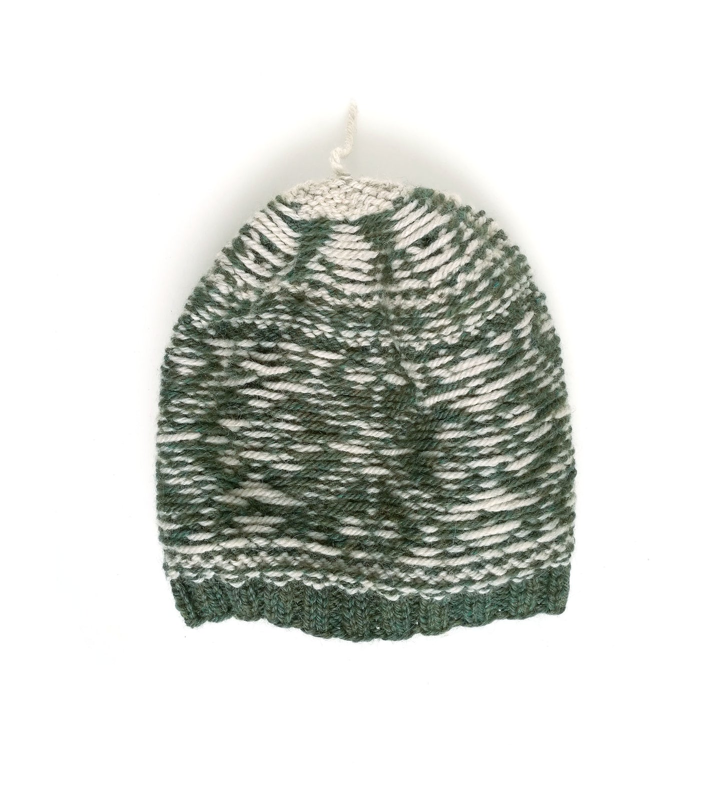 A hand-knit beanie hat featuring a marled pattern of forest green and off-white yarn, with a solid green ribbed brim and a small white hanging loop at the top, shown against a plain white background.