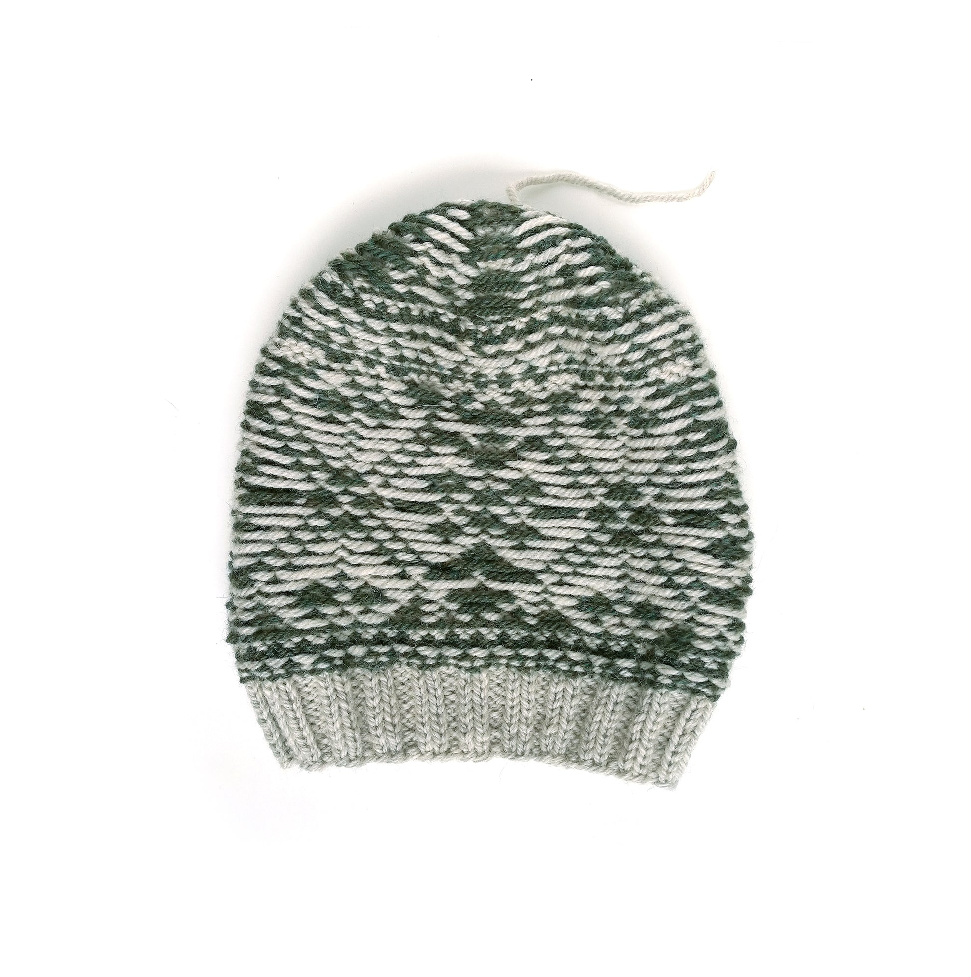 A beige and green wool hand-knitted Fair Isle beanie hat with a snowflake motif, inside out