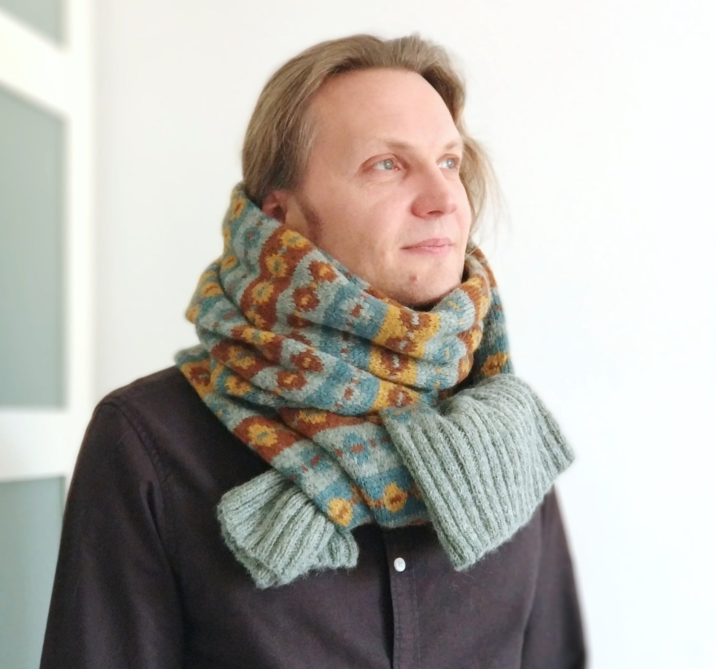 a man performs Grey, brown, yellow and blue alpaca wool hand-knitted Fair Isle long scarf