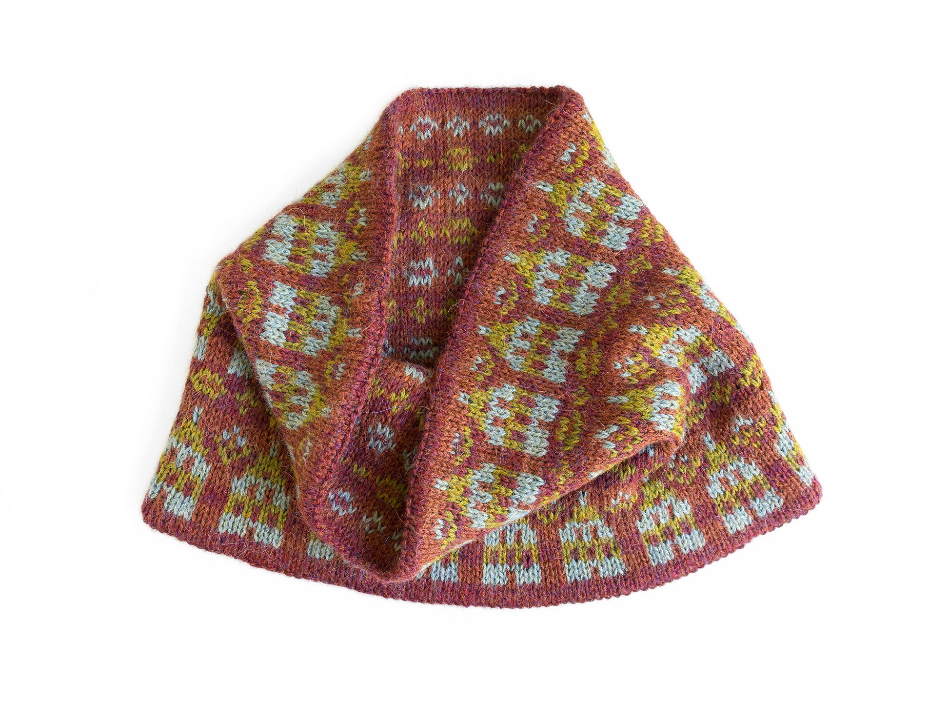 A hand-knit cowl scarf with a Fair Isle pattern in dusty rose, mustard yellow, and light blue, shown on a plain white background.