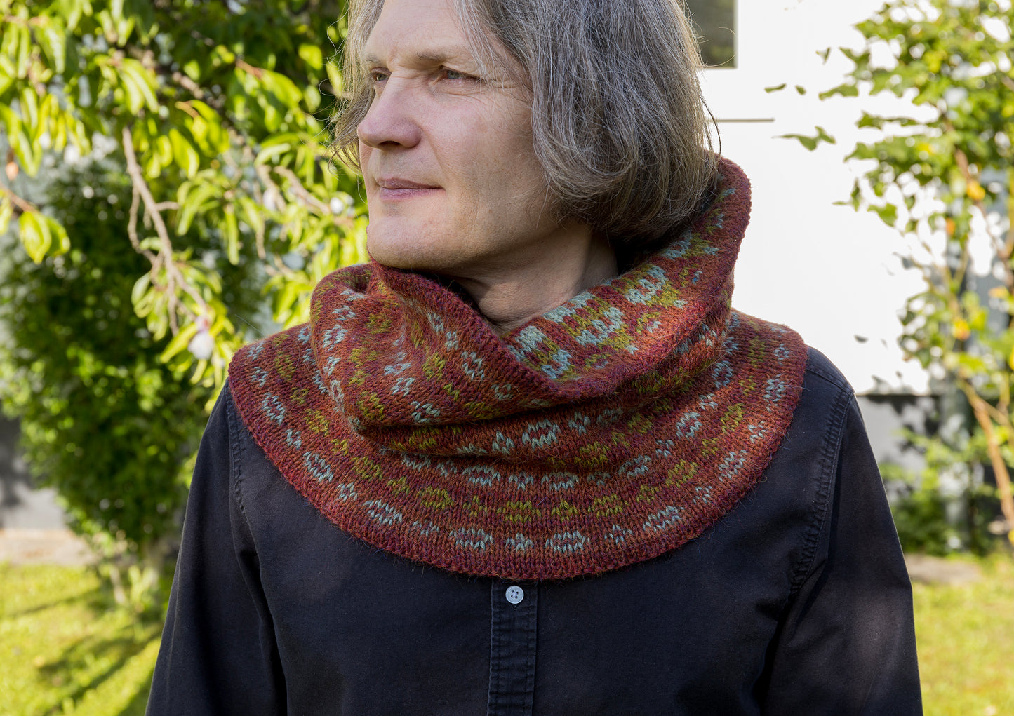 Person wearing a patterned cowl in an outdoor setting